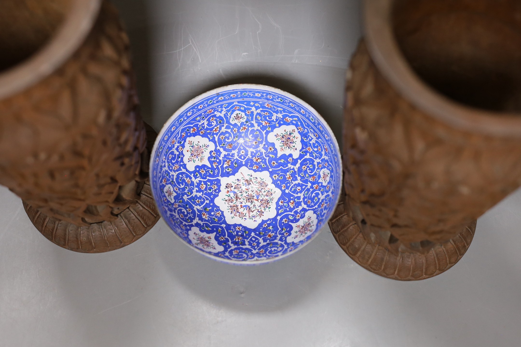 A pair of Indian carved wood vases, 22.5cm high, and a Persian blue enamel bowl (3)